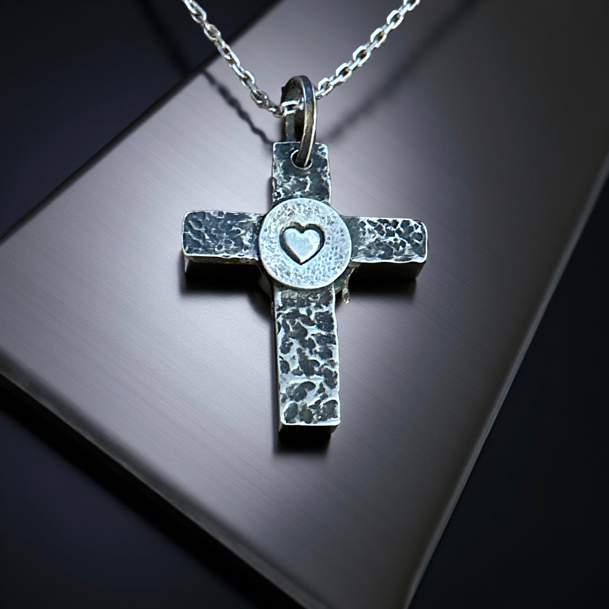Handcrafted sterling silver cross pendant with melting heart design.