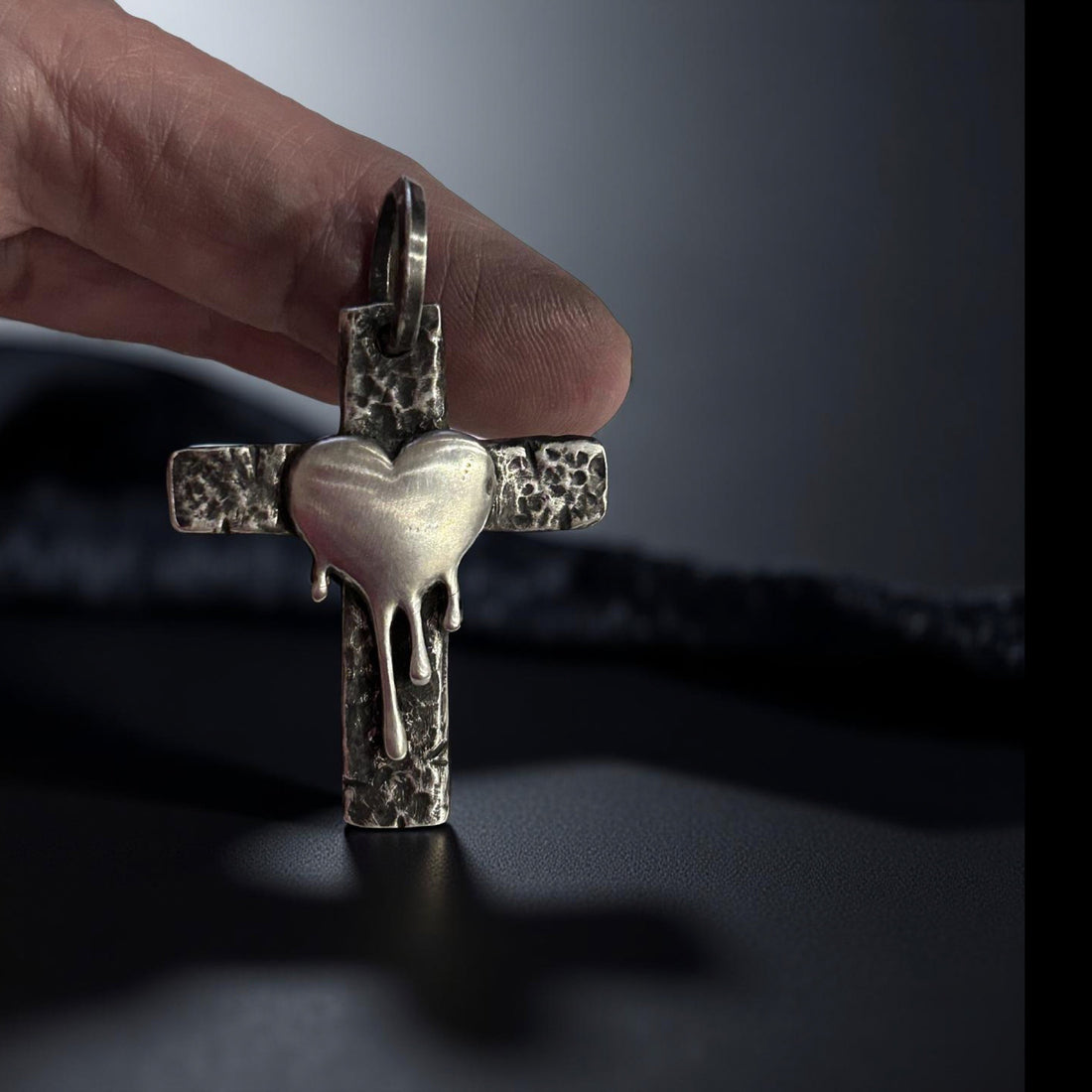 Handcrafted sterling silver cross pendant with melting heart design.