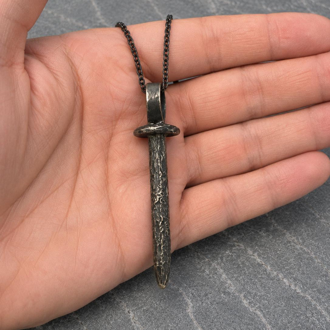 Oxidized stake coffin nail pendant on a chain, jewelry piece from JJewelryArt with detailed metalwork and dark finish.